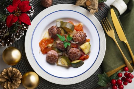 Téléchargez les photos : Boulettes de viande avec sauce tomate et légumes. Nourriture de Noël sur une table avec décorations. - en image libre de droit