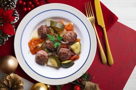 Foto de Albóndigas de carne con salsa de tomate y verduras. Comida de Navidad en una mesa con decoraciones. - Imagen libre de derechos