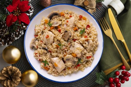 Téléchargez les photos : Paella de riz avec dinde et légumes. Une recette saine. Nourriture de Noël servie sur une table décorée de motifs de Noël. - en image libre de droit