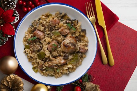 Téléchargez les photos : Rice paella with rabbit, sausages and green beans. Tapa traditional recipe in Valencia, Spain. Christmas food served on a table decorated with Christmas motifs. - en image libre de droit