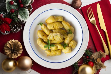 Photo for Breaded artichokes cover. Typical Spanish vegan tapas. Christmas food served on a table decorated with Christmas motifs. - Royalty Free Image
