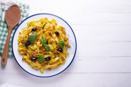 Photo for Pasta ribbons with sauted pumpkin and black olives. - Royalty Free Image