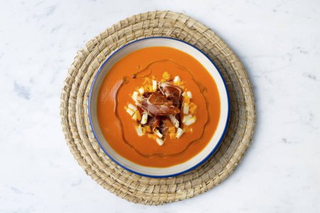 Téléchargez les photos : Salmorejo espagnol traditionnel. Soupe de tomates froides servie avec oeuf et confiture d'iberico. - en image libre de droit