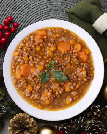 Photo for Lentils with chorizo and black blood sausage. Christmas food served on a table decorated with Christmas motifs. - Royalty Free Image