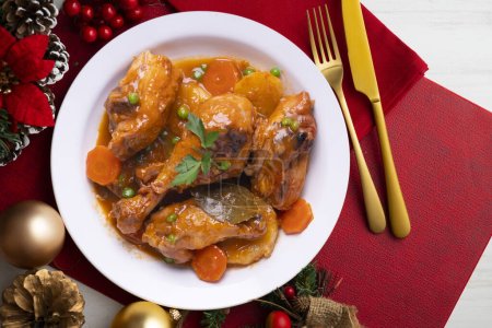 Photo for Chicken thighs cooked in the oven with vegetables. Food served on a table with Christmas decorations. - Royalty Free Image