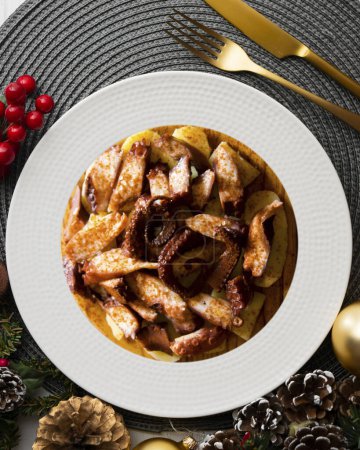 Téléchargez les photos : Pulpo a la Gallega. Poulpe cuit avec pomme de terre bouillie, paprika et huile d'olive. Recette de poulpe galicien au nord de la tapa espagnole. Décoration de table de Noël. - en image libre de droit