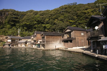 Téléchargez les photos : Beau village de pêcheurs d'Ine au nord de Kyoto. Funaya ou maisons de bateau sont des maisons traditionnelles en bois construites sur le bord de la mer. - en image libre de droit