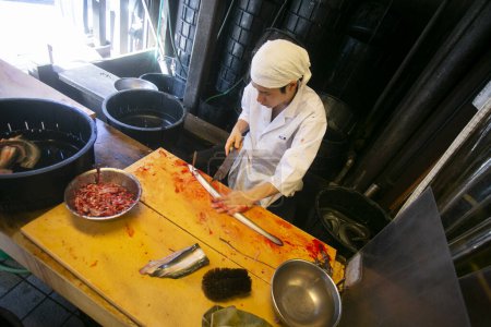 Téléchargez les photos : Narita, Japon ; 1er octobre 2023 : Chef japonais préparant et nettoyant une anguille. L'anguille fumée grillée est la nourriture la plus traditionnelle à Narita. - en image libre de droit
