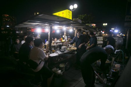 Téléchargez les photos : Fukuoka, Japon ; 1er octobre 2023 : Les gens mangent et boivent dans un Yatai dans la baie d'Hakata. Un Yatai est un petit étal de nourriture mobile au Japon qui vend généralement des ramen ou d'autres aliments.. - en image libre de droit