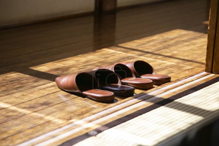 Téléchargez les photos : Pantoufles en cuir domestique à l'entrée d'une maison japonaise avec parquet. - en image libre de droit