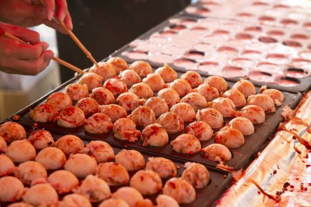Photo for Takoyaki is a Japanese food made from wheat flour and octopus. It is made in the shape of a ball. - Royalty Free Image