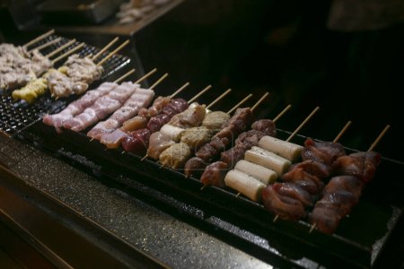 Téléchargez les photos : Brochettes de poulet yakitori grillées dans un restaurant Izakaya dans la rue Omoide Yokocho dans le quartier Shinjuku de Tokyo. - en image libre de droit