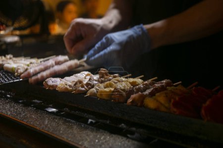 Téléchargez les photos : Brochettes de poulet yakitori grillées dans un restaurant Izakaya dans la rue Omoide Yokocho dans le quartier Shinjuku de Tokyo. - en image libre de droit
