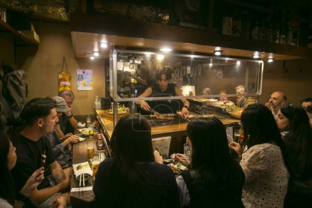 Foto de Tokio, Japón; 1 de octubre de 2023: Ambiente en el restaurante Izakaya en la calle Omoide Yokocho en el distrito Shinjuku de Tokio. - Imagen libre de derechos