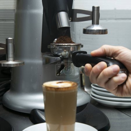 Photo for Professional barista working with a coffee machine and preparing hot drinks with coffee and milk. - Royalty Free Image
