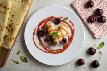 Téléchargez les photos : Délicieuses crêpes françaises aux cerises fraîches et sirop de fruits rouges. - en image libre de droit
