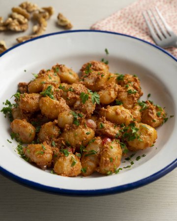 Téléchargez les photos : Gnocchi avec sauce au pesto rosso. Gnocchi aux pommes de terre italiennes avec sauce traditionnelle. - en image libre de droit