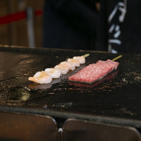 Foto de Carne japonesa Kobe Wagyu en un puesto de comida en el Mercado Exterior de Tsukiji en la ciudad de Tokio, Japón. - Imagen libre de derechos