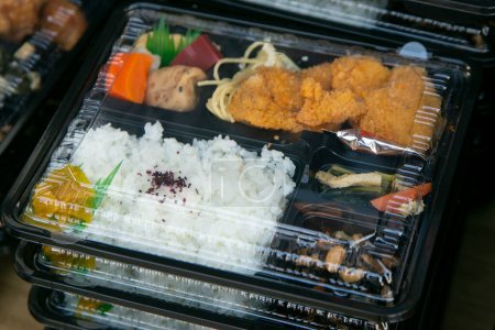 Téléchargez les photos : Bento est une portion prête à l'emploi de la nourriture, assez commune dans la cuisine japonaise. Traditionnellement, il comprend généralement du riz, du poisson ou de la viande, ainsi qu'une garniture ou un accompagnement à base de légumes.. - en image libre de droit