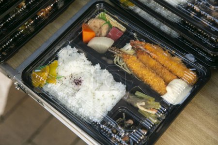 Téléchargez les photos : Bento est une portion prête à l'emploi de la nourriture, assez commune dans la cuisine japonaise. Traditionnellement, il comprend généralement du riz, du poisson ou de la viande, ainsi qu'une garniture ou un accompagnement à base de légumes.. - en image libre de droit