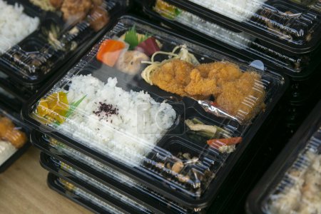 Foto de Bento es una porción de comida lista para llevar, bastante común en la cocina japonesa. Tradicionalmente suele incluir arroz, pescado o carne, y una guarnición o acompañamiento a base de verduras.. - Imagen libre de derechos