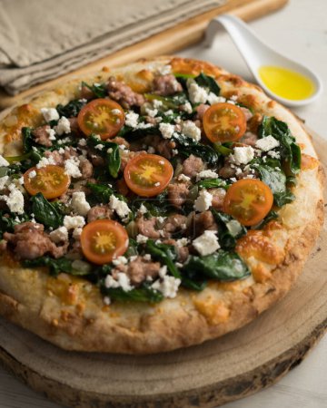 Photo for Neapolitan pizza with sausage and spinach. - Royalty Free Image