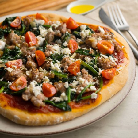 Photo for Neapolitan pizza with sausage and spinach. - Royalty Free Image