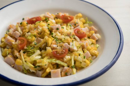 Téléchargez les photos : Salade de dinde, maïs, chou et mayonnaise. Recette traditionnelle de salade pour l'été. - en image libre de droit