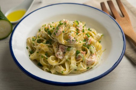 Photo for Tagliatelle pasta dish with salmon and zucchini - Royalty Free Image