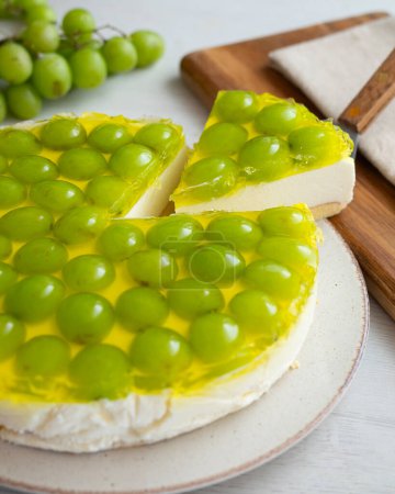 Foto de Tarta de queso con uvas sobre una base de bizcocho. - Imagen libre de derechos