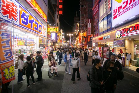Foto de Osaka, Japón; 20 de octubre de 2023: Restaurantes y turistas en las calles de Dotonbori llenos de puestos de comida callejera y vida nocturna. - Imagen libre de derechos