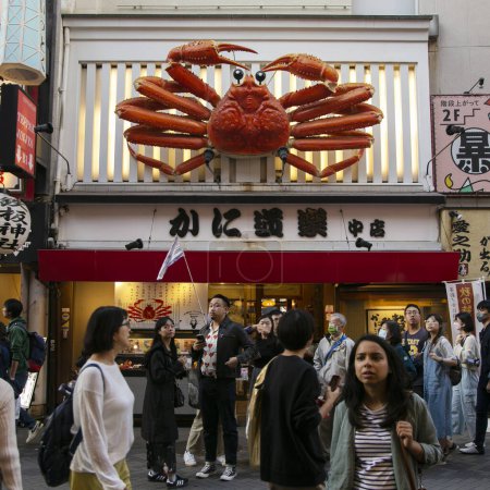 Foto de Osaka, Japón; 20 de octubre de 2023: Restaurantes y turistas en las calles de Dotonbori llenos de puestos de comida callejera y vida nocturna. - Imagen libre de derechos