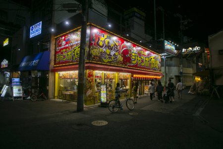 Foto de Osaka, Japón; 20 de octubre de 2023: Restaurante Takoyaki en el distrito de Dontonbori con los turistas. - Imagen libre de derechos