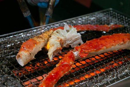 Téléchargez les photos : Jambes de crabe royal cuites sur un barbecue dans la ville d'Osaka au Japon. - en image libre de droit
