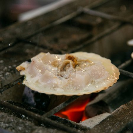 Foto de Concha de mariscos y pescado cocinados a la parrilla en el mercado de pescado de Osaka en Japón. - Imagen libre de derechos