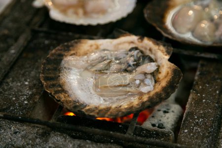 Photo for Seafood shell and fish cooked on a grill at the Osaka fish market in Japan. - Royalty Free Image