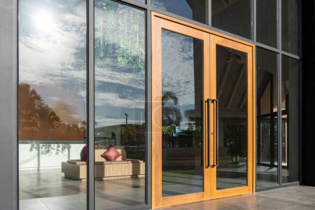 Foto de Puerta de entrada de cristal a un gran hotel de apartamentos, el material es de madera y acero, bellamente decorado. - Imagen libre de derechos