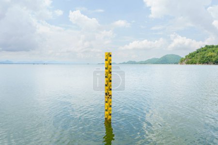 Téléchargez les photos : L'échelle jaune mesure la hauteur de l'eau dans le barrage. L'eau dans le réservoir est abondante et est utilisée pour l'agriculture et la consommation du village.Réservation de la nature aquatique en Thaïlande - en image libre de droit