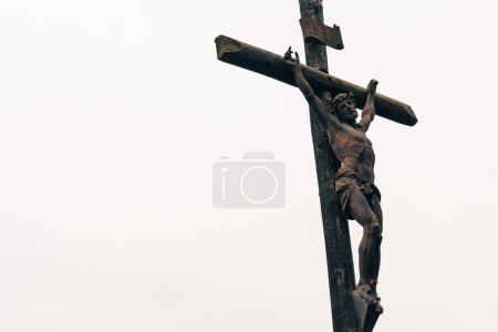 Christusfigur gekreuzigt am Kreuz eines Tempels auf einem Friedhof an einem bewölkten Tag im Freien
