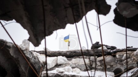 Ukrainische Flagge sichtbar durch das Loch in der Decke der zerstörten Schule im nicht besetzten Dorf Cherson Region. Die Kriegsrealität in der Ukraine