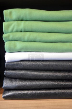 Photo for Stack of gray and black clothes on a shelf in clothing store. Clothing store fashion. - Royalty Free Image