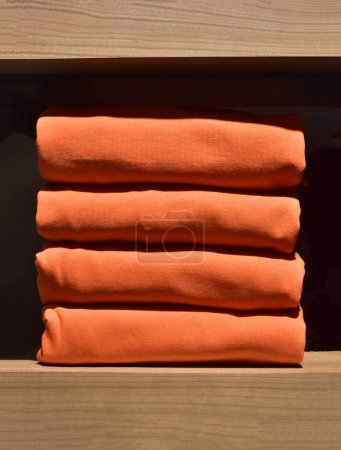 Photo for Stack of red clothes on a shelf in clothing store. Clothing store fashion. - Royalty Free Image