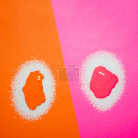 Pilas de azúcar anaranjadas y rosadas con color. Concepto alimentario creativo.