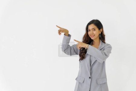 Photo for Happy young asian beautiful business woman stand pointing fingers to copy space on white isolated background. - Royalty Free Image