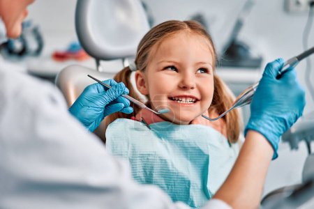 Children's dentistry. Live funny photo of a child who laughs at the dentist's appointment and looks away. Copy space.