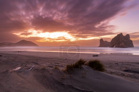 Téléchargez les photos : Wharariki Beach est une plage sur la mer de Tasman, à l'ouest du cap Farewell, le point le plus au nord de l'île du Sud de la Nouvelle-Zélande - en image libre de droit