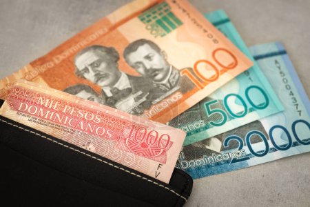 Moneda de República Dominicana, billetes de pesos, sobresaliendo de la billetera, primer plano, concepto de negocio de viajes