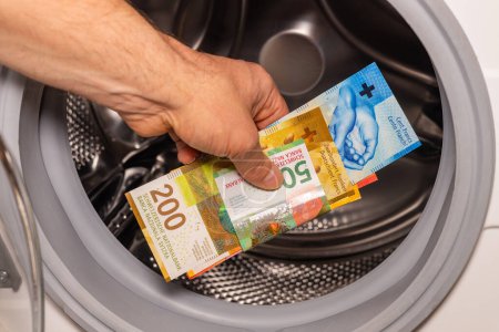 Foto de Franco suizo arrojado a la lavadora, concepto, lavado de dinero, actividad ilegal, mercado negro, actividad delictiva - Imagen libre de derechos