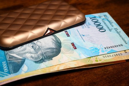 Téléchargez les photos : Venezuela argent, Un paquet de billets de banque sortant d'un beau portefeuille en or pour les cartes et l'argent - en image libre de droit