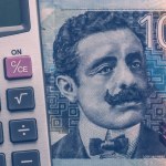 Peru money, 100 soles banknote and calculator, Financial calculations concept, close up